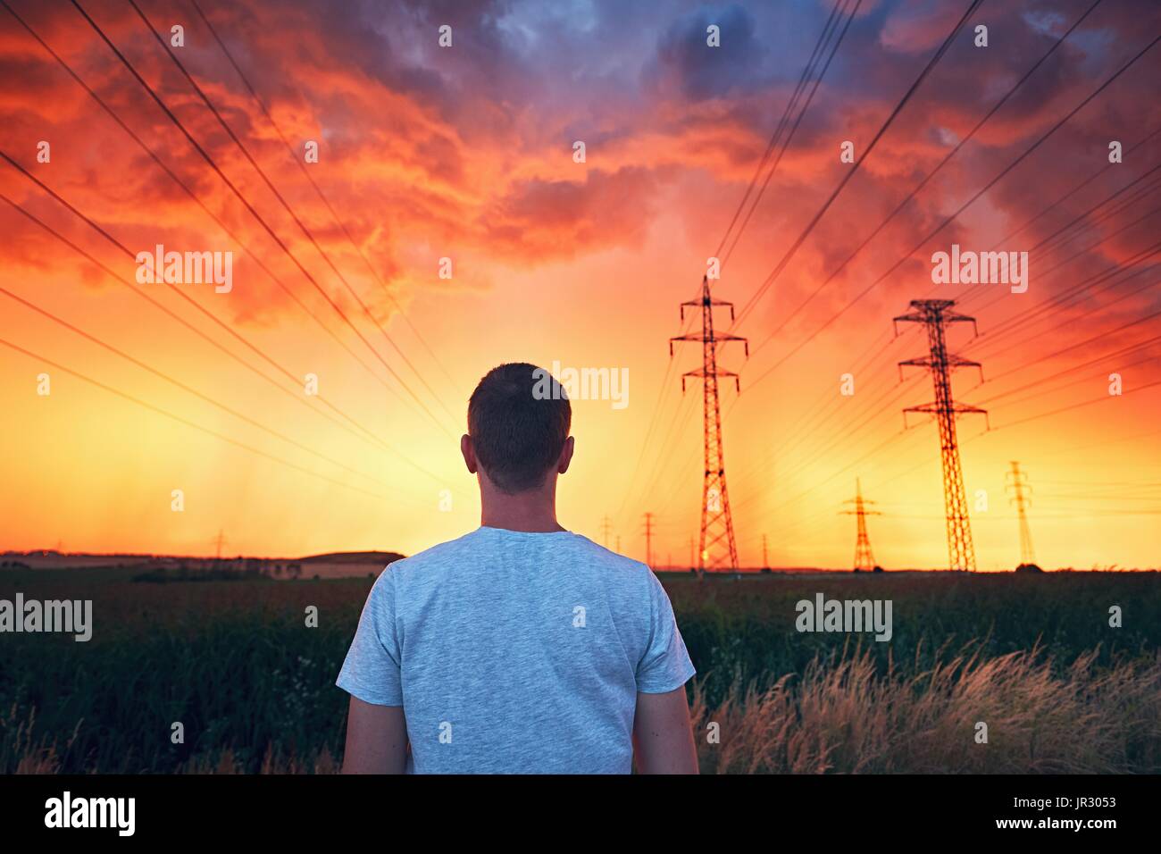 Dangerous weather. Lonely man in stunning storm during colorful sunset. Stock Photo