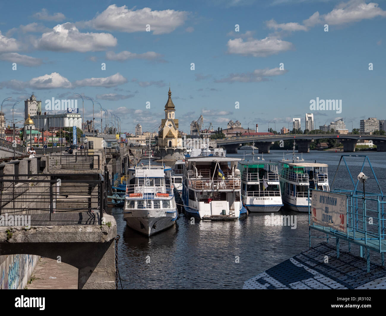KIEV, UKRAINE - JUNE 12, 2016:  Tourist boats at the Kiev River Port on the Dnieper River with the St. Nicolas Wondermaker on The Water Church Stock Photo
