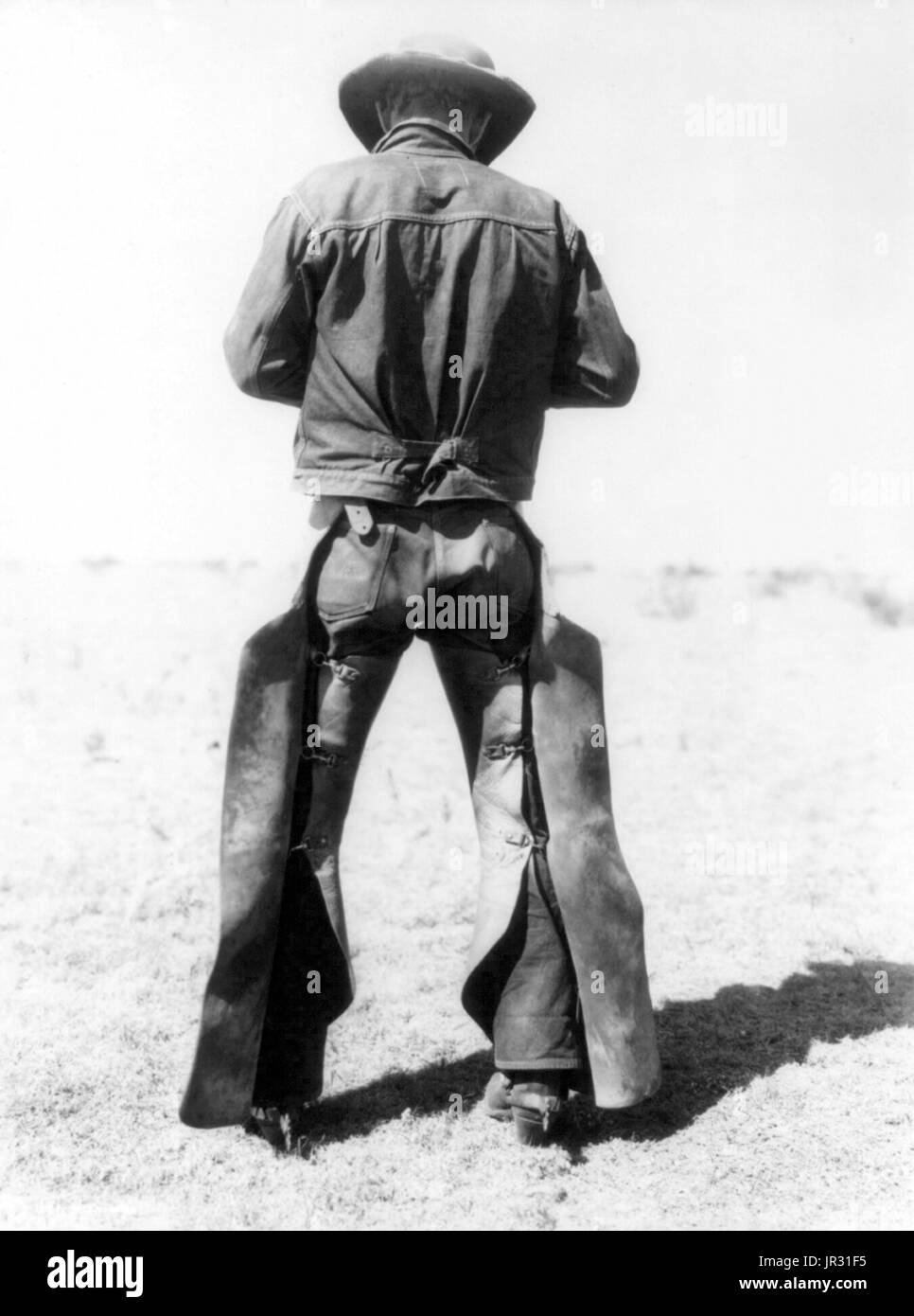 Rear view of cowboy wearing chaps and spurs. The historic American cowboy of the late 19th century arose from the vaquero traditions of northern Mexico and became a figure of special significance and legend. By the late 1860s, following the American Civil War and the expansion of the cattle industry, former soldiers from both the Union and Confederacy came west, seeking work, as did large numbers of restless white men in general. A significant number of African-American freedmen also were drawn to cowboy life, in part because there was not quite as much discrimination in the west as in other a Stock Photo