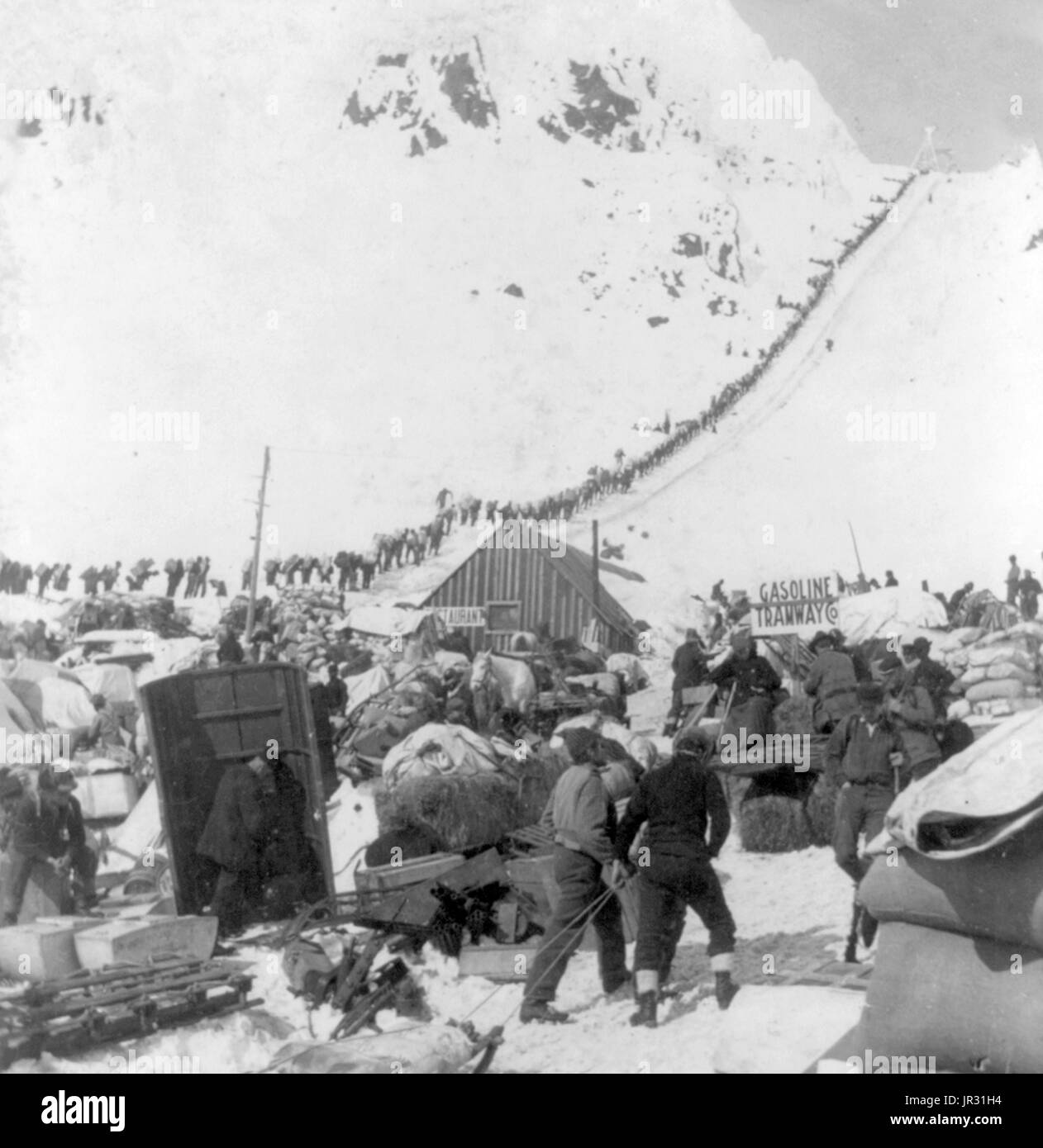 Bound for the Klondike Gold Fields, Chilcoot Pass, Alaska. The Klondike Gold Rush was a migration by an estimated 100,000 prospectors to the Klondike region of the Yukon between 1896-99. Gold was discovered by local miners on August 16, 1896 and, when news reached Seattle and San Francisco, it triggered a stampede of would-be prospectors. To reach the gold fields most took the route through the ports of Dyea and Skagway in Alaska. Here, the Klondikers could follow either the Chilkoot or the White Pass trails to the Yukon River and sail down to the Klondike. Each of them was required to bring a Stock Photo