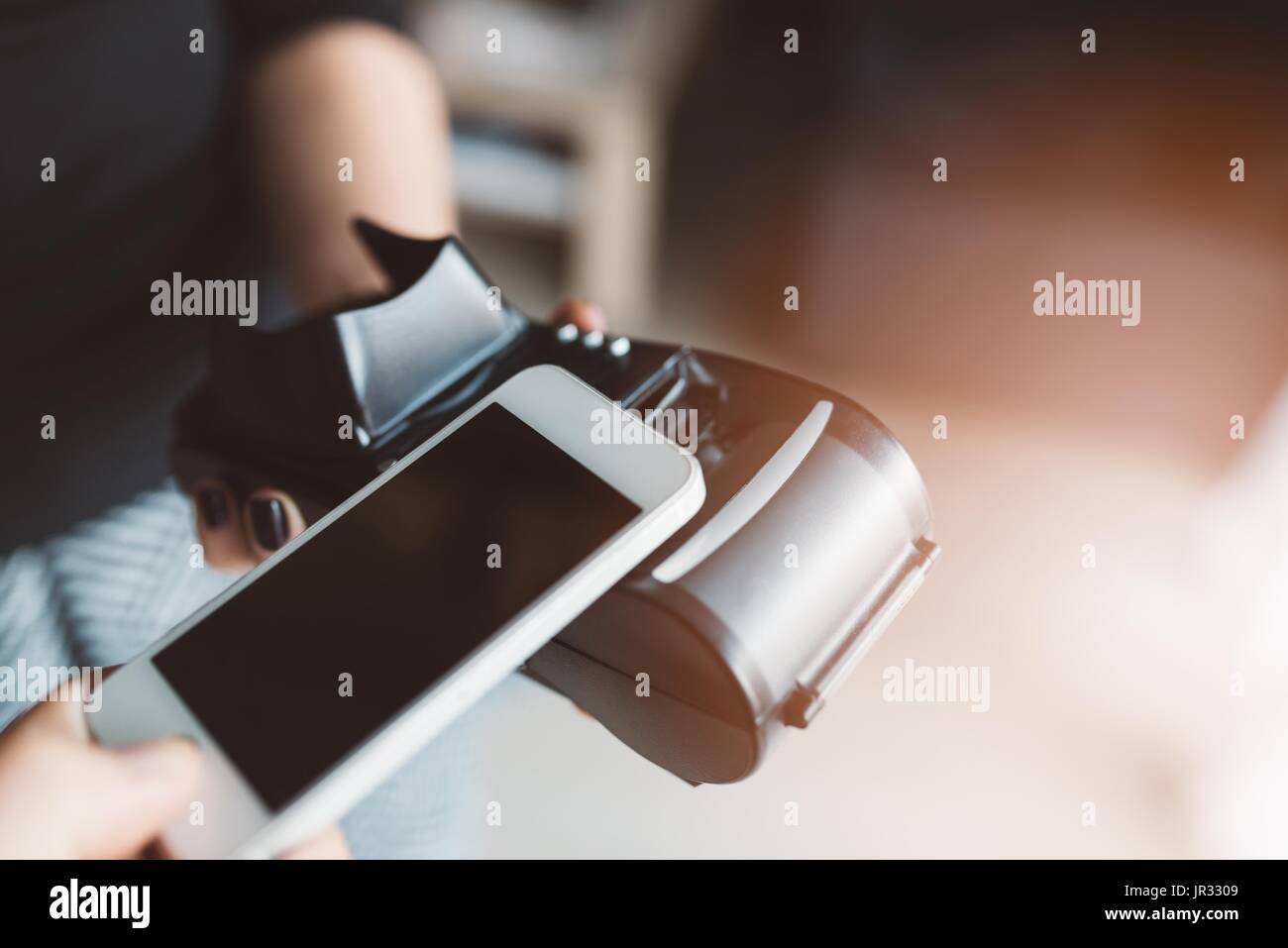Man using NFC technology on smart phone to pay bill Stock Photo