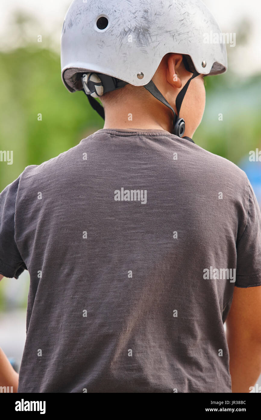 Skater child with helmet ready to jump. Green background. Vertical