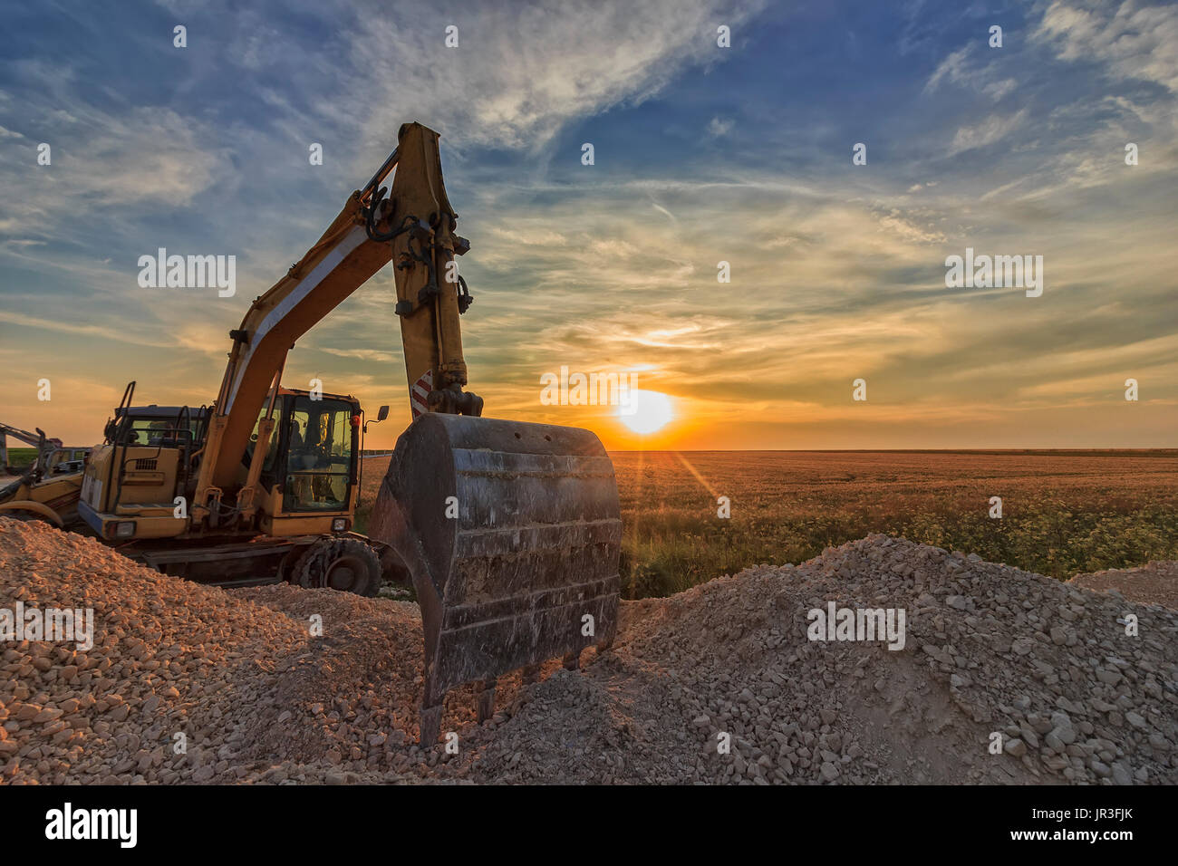 excavator in construction site at stunning sunset Stock Photo - Alamy