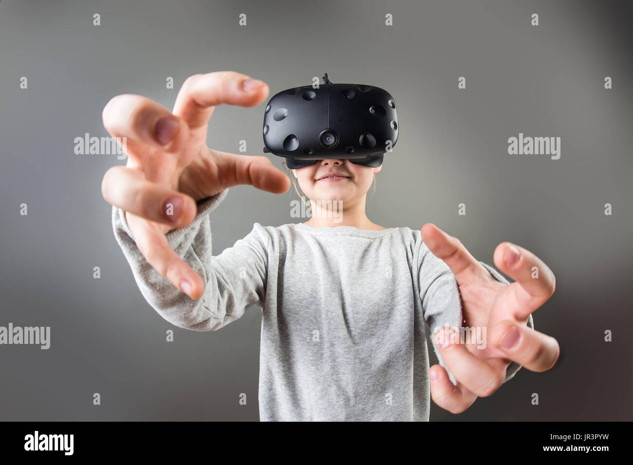 girl wearing virtual reality goggles standing on grey background. VR glasses. 360 degrees