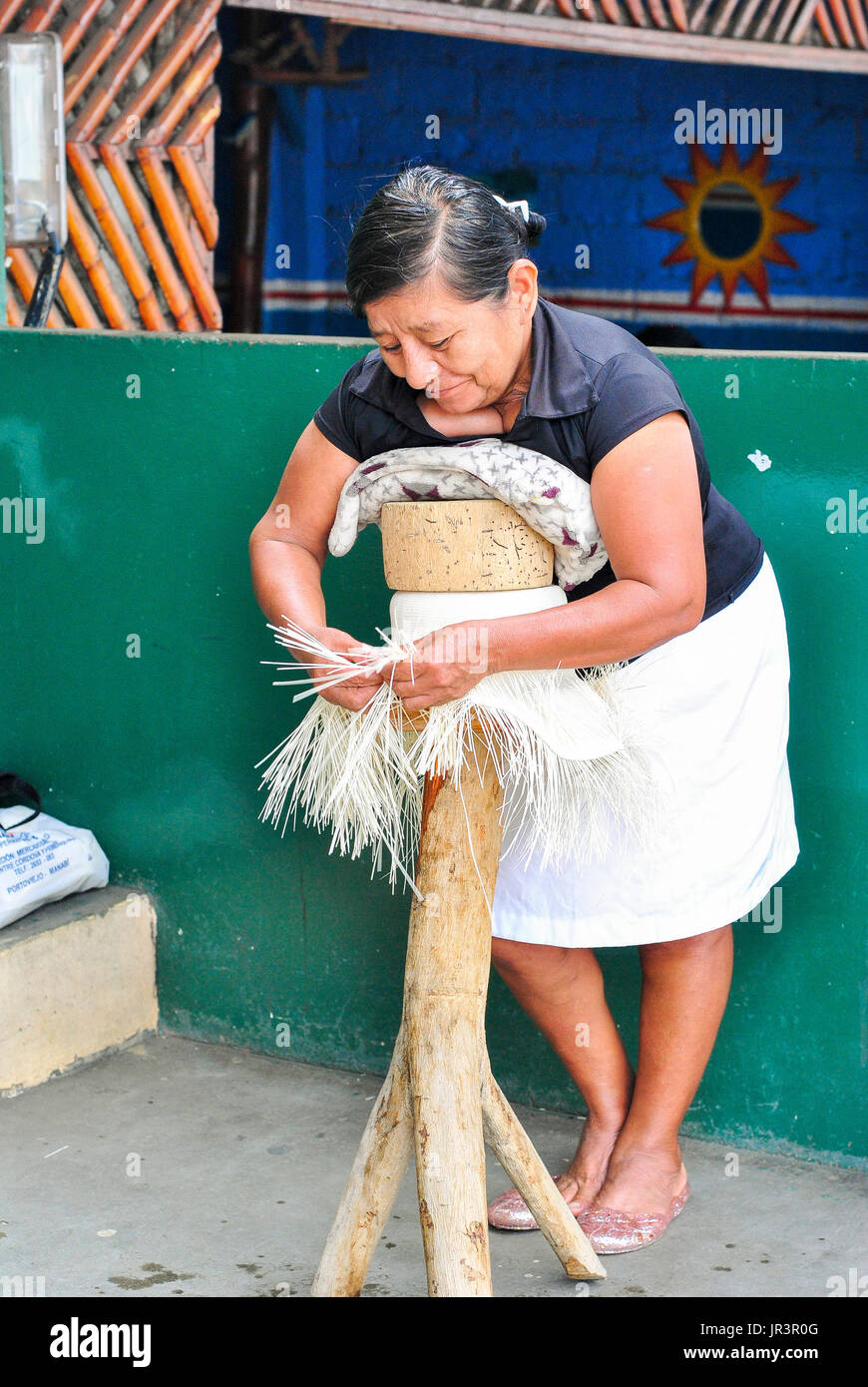 A woman weaving toquilla straw hat, known as Panama Hat. Brimmed straw