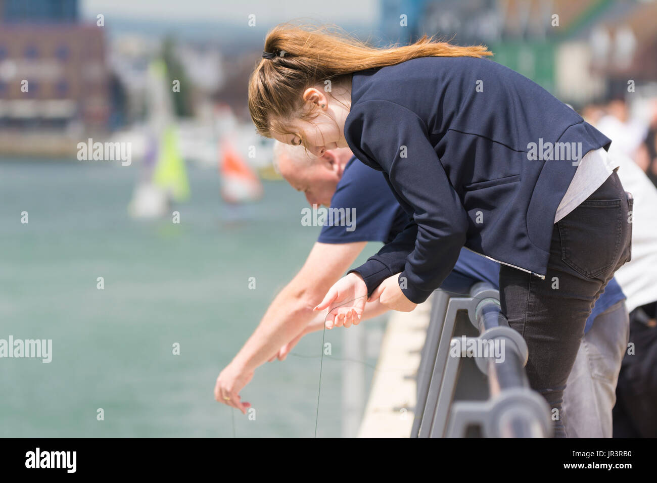 Young girl crab fishing in a river in the UK. Stock Photo