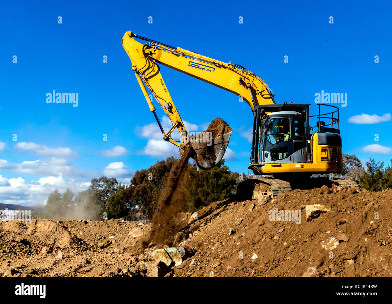 Front end loader works to move pile of dirt Stock Photo