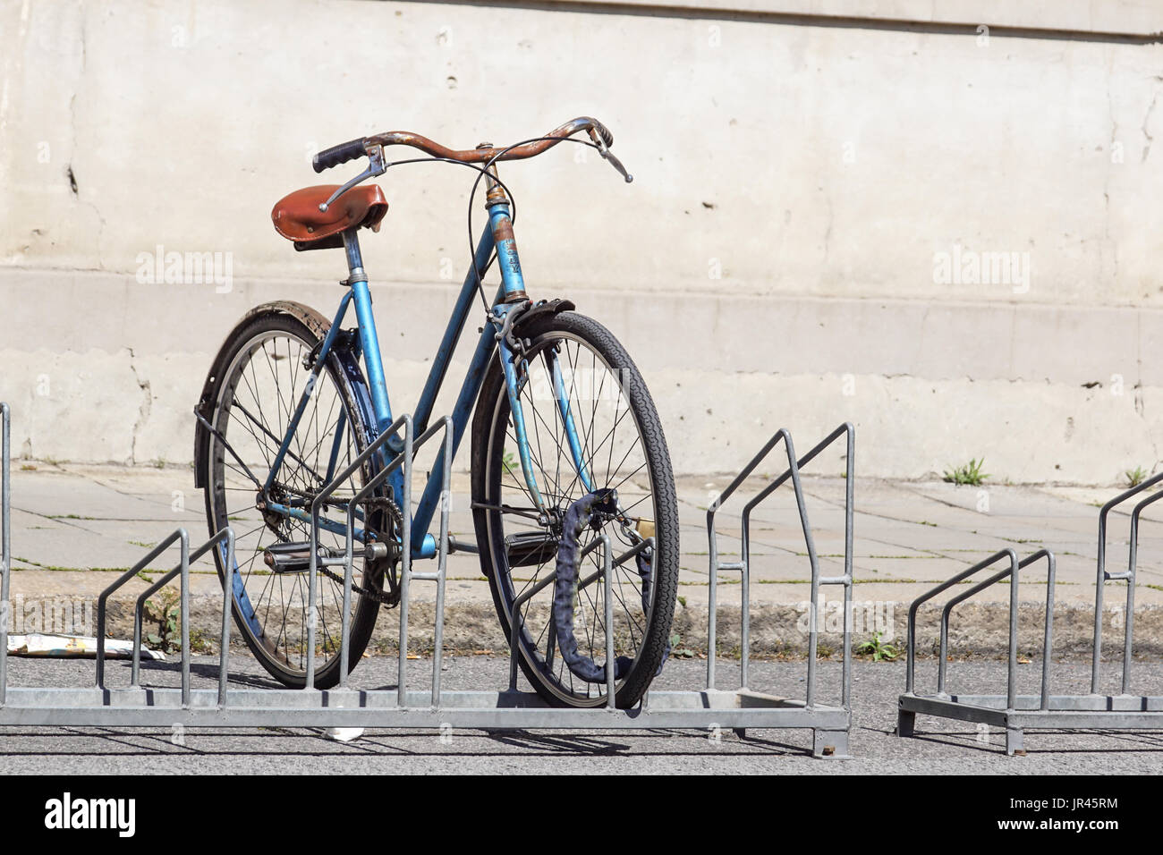 Bicycle parked in the street on the bicycle rack Stock Photo Alamy