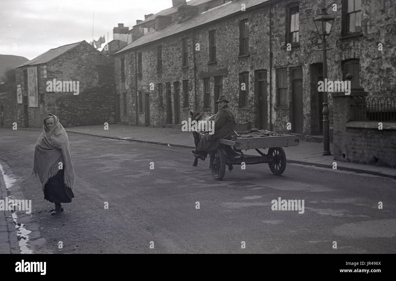 1940s, historical, man on pony and cart in a quiet empty street of small victorian terraced houses in Merthyr Tydfil, South Wales. He would be selling cockles he had sourced from the local beach door to door. Stock Photo