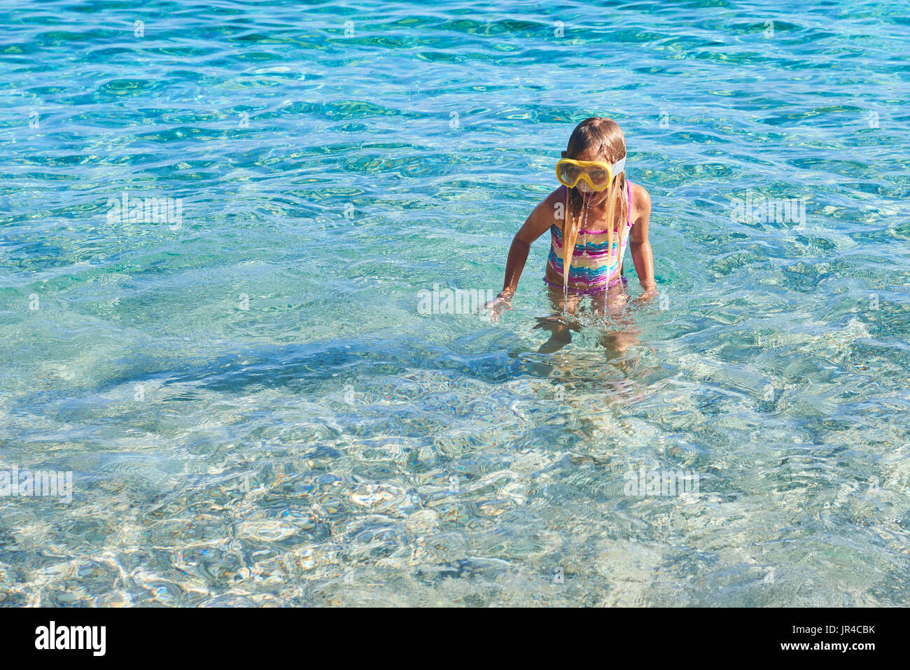 Child little girl wearing diving goggles in the sea. Portrait of a cute ...