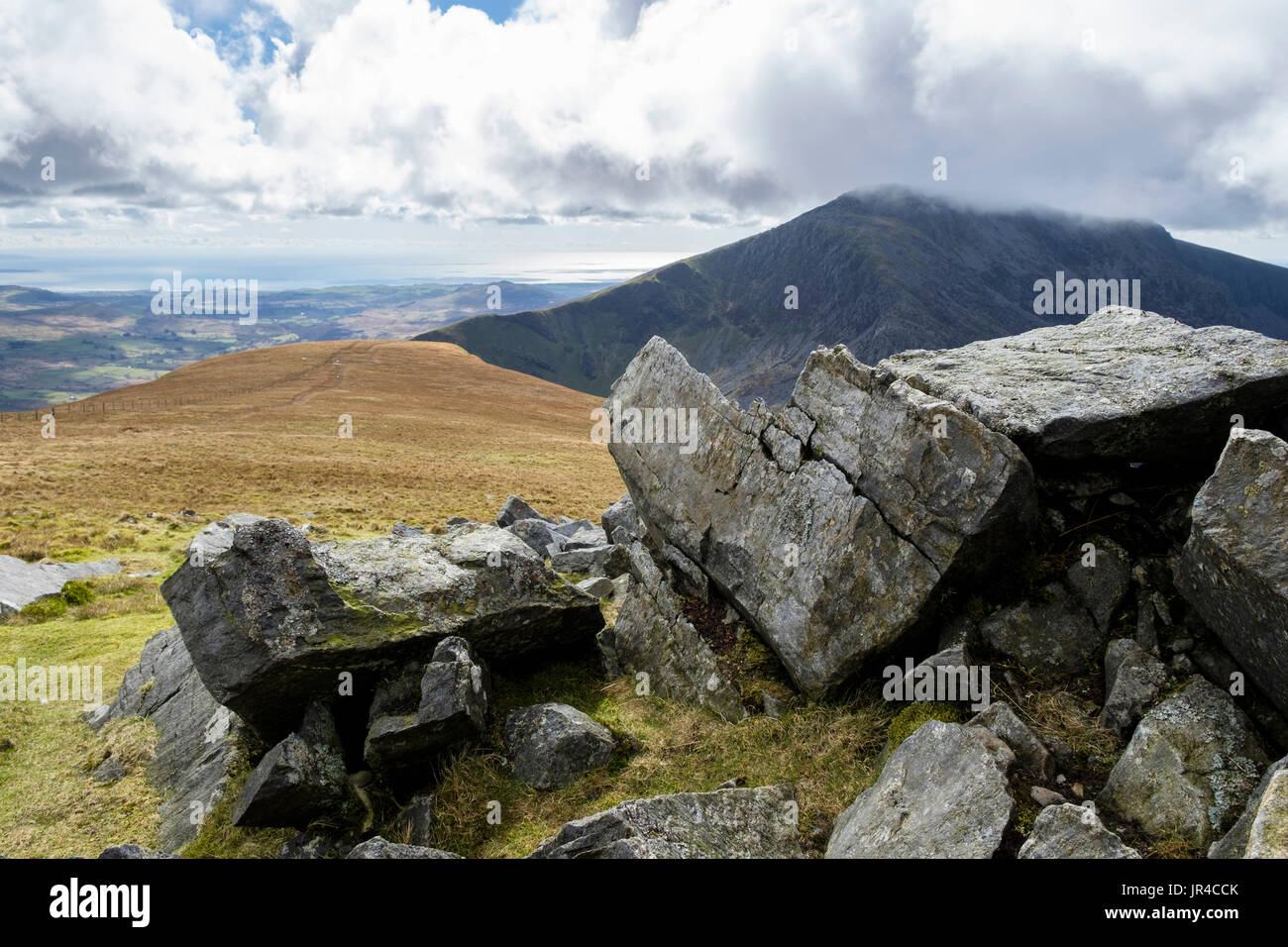 Fractured boulders on Mynydd Tal-y-mignedd with Craig Cwm Silyn beyond on Nantlle Ridge in mountains of Snowdonia National Park. Gwynedd Wales UK Stock Photo