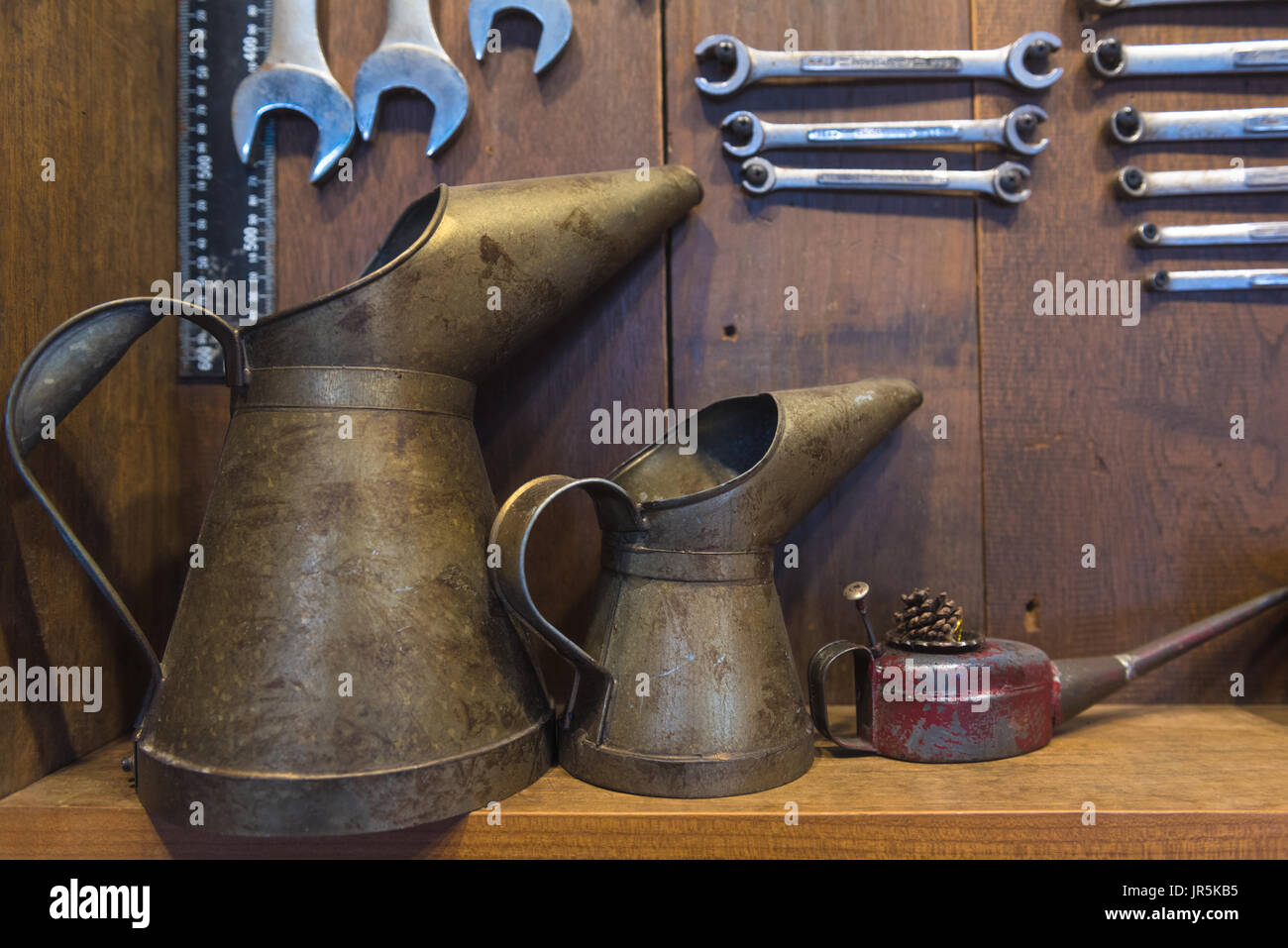 oil can metal big and small on the table with spanner on wood background Stock Photo