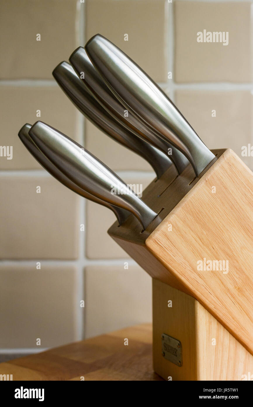 Sharp knives in a wooden knife block in a domestic kitchen Stock Photo