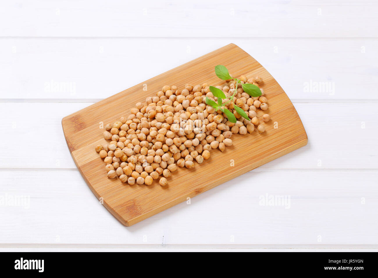 pile of raw chickpeas on wooden cutting board Stock Photo