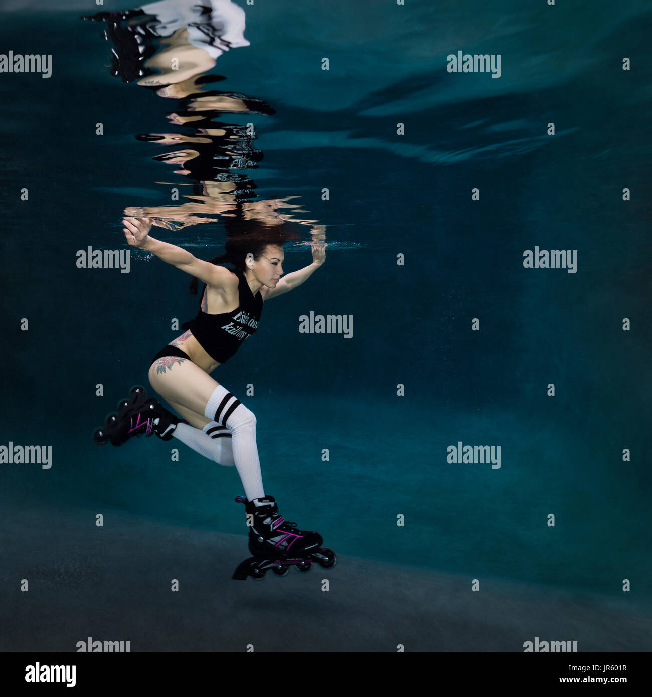 Young woman roller blading underwater, Virginia Beach, VA Stock Photo