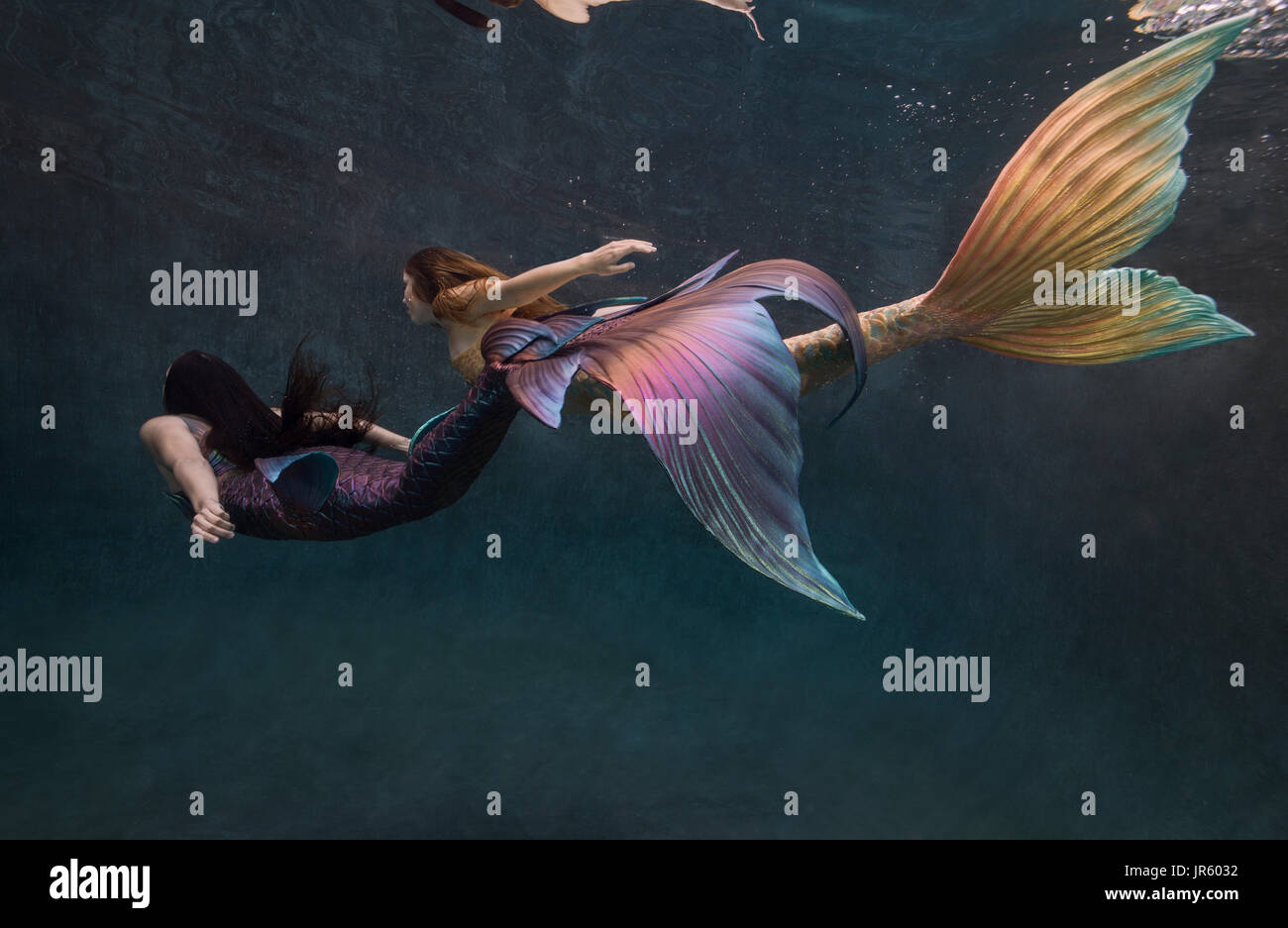 Two mermaids swimming in a pool in Virginia Beach, VA Stock Photo