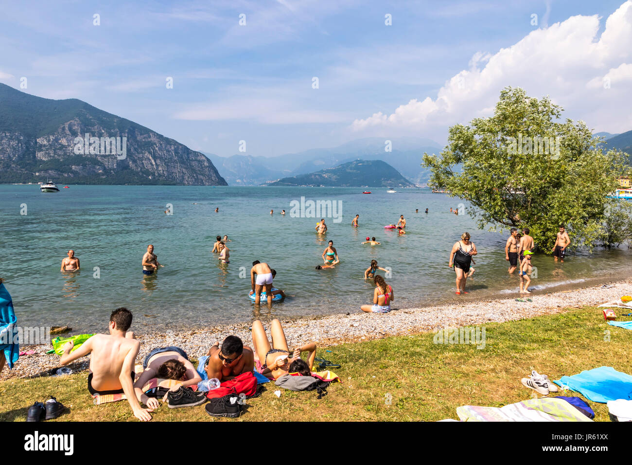 ISEO, ITALY - JUNE 17, 2017: Crowded summer beach on Iseo lake, Iseo city, Lombardy, Italy. Lake Iseo or Lago d'Iseo or Sebino is the 4th largest lake Stock Photo