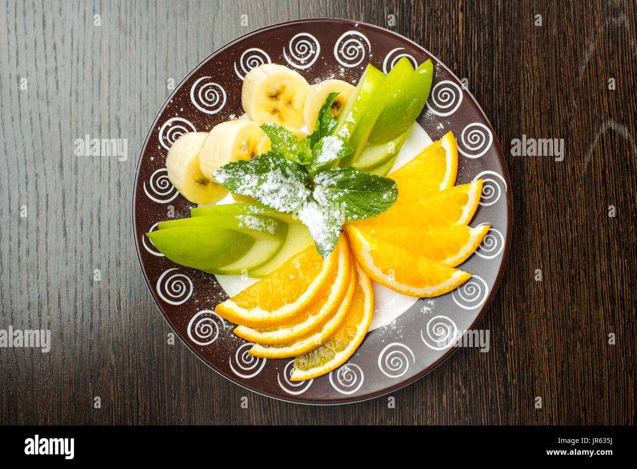 Vegan breakfast variety of fruits, nuts and berries on the grey wooden