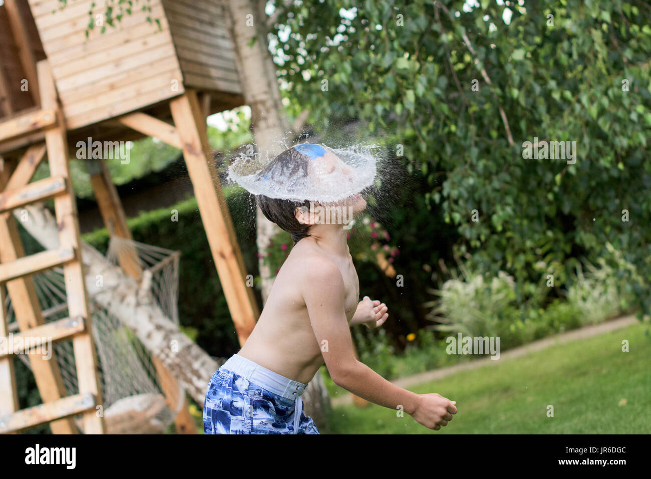 Water bomb landing on a boy's face Stock Photo