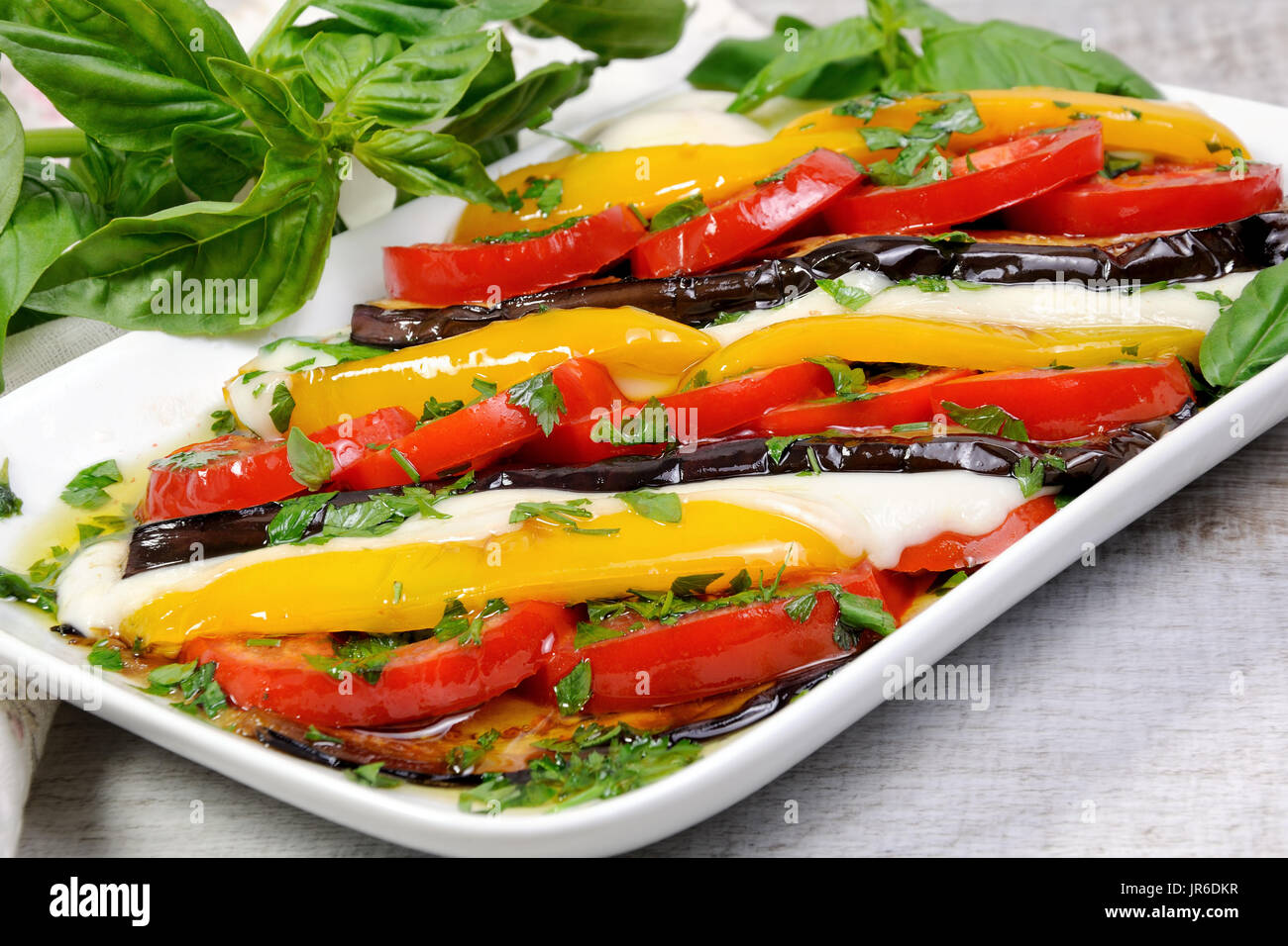 Baked eggplants with tomatoes, yellow pepper and slices mozzarella