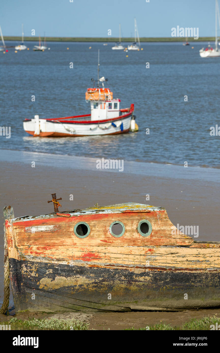 Beached rotting wooden boats in the muddy estuary at Orford, Suffolk. Stock Photo