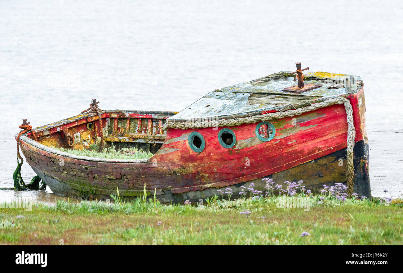 Beached rotting wooden boats in the muddy estuary at Orford, Suffolk. Stock Photo
