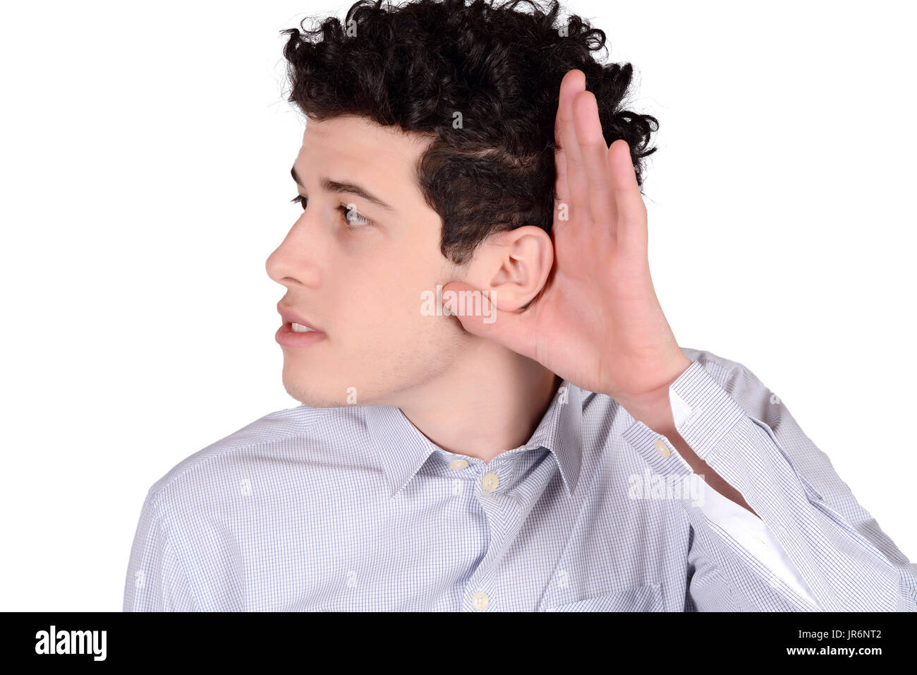 Portrait of attractive young man hearing something. Isolated white background. Stock Photo