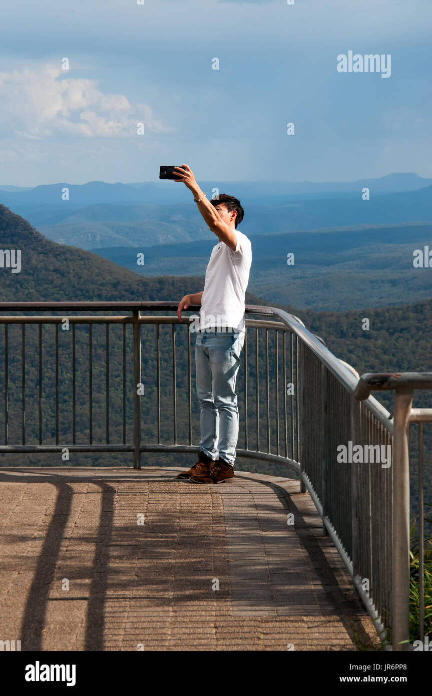 Katoomba, Australia - October 20, 2015: Unidentified tourist taking a selfie with smart phone in Blue Mountain view point in New South Wales, Australi Stock Photo