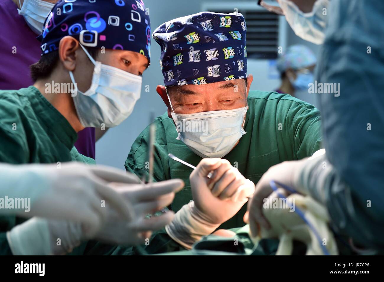 (170804) -- JINAN, Aug. 4, 2017 (Xinhua) -- Qi Qingliang (right), President of Yuanquan Central Health Center of Boshan District does an operation in Zibo, east China's Shandong Province, Aug. 3, 2017. 65-year-old Qi Qingliang, the representative of the 19th National Congress of the Communist Party of China(CPC), has worked hard every day to help the patients. When he graduated from university in 1978, he had the chance to stay at the school but he refused it and returned to Boshan District Hospital which located in the mountain area of his hometown. In 1997, as one of the top 10 famous doctor Stock Photo