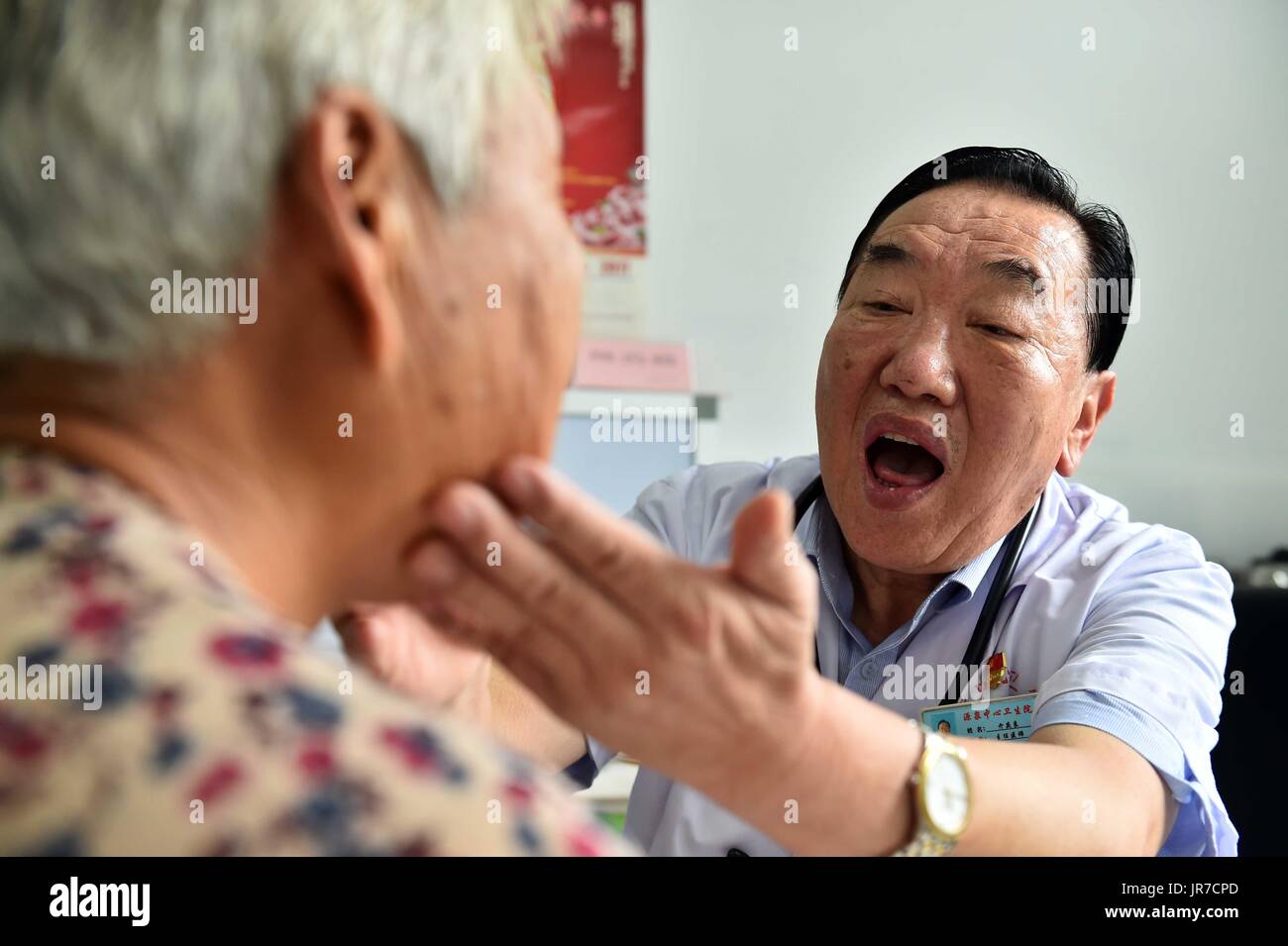 (170804) -- JINAN, Aug. 4, 2017 (Xinhua) -- Qi Qingliang, President of Yuanquan Central Health Center of Boshan District diagnoses a patient in Zibo, east China's Shandong Province, Aug. 3, 2017. 65-year-old Qi Qingliang, the representative of the 19th National Congress of the Communist Party of China(CPC), has worked hard every day to help the patients. When he graduated from university in 1978, he had the chance to stay at the school but he refused it and returned to Boshan District Hospital which located in the mountain area of his hometown. In 1997, as one of the top 10 famous doctors in Stock Photo
