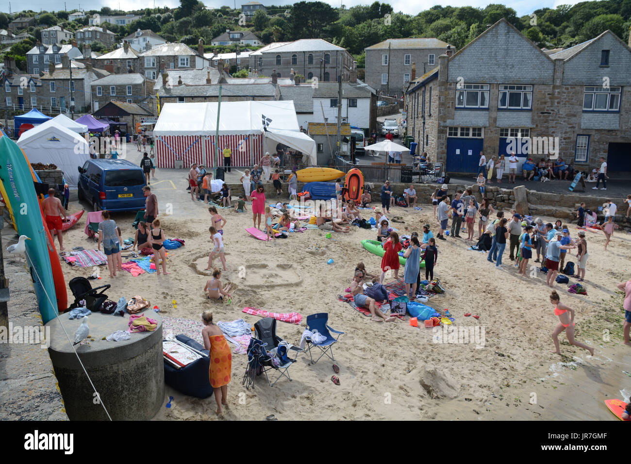 Mousehole, Cornwall, UK. 3rd August 2017. UK Weather. It was a sunny start for the annual Mousehole carnival which runs over the weekend. The afternoon saw a sand sculpture competition on the tiny harbour beach. At high tide locals and holiday makers enjoyed leaping off the harbour walls into the sea - which had a reported temperature of 21 degrees C Credit: cwallpix/Alamy Live News Stock Photo