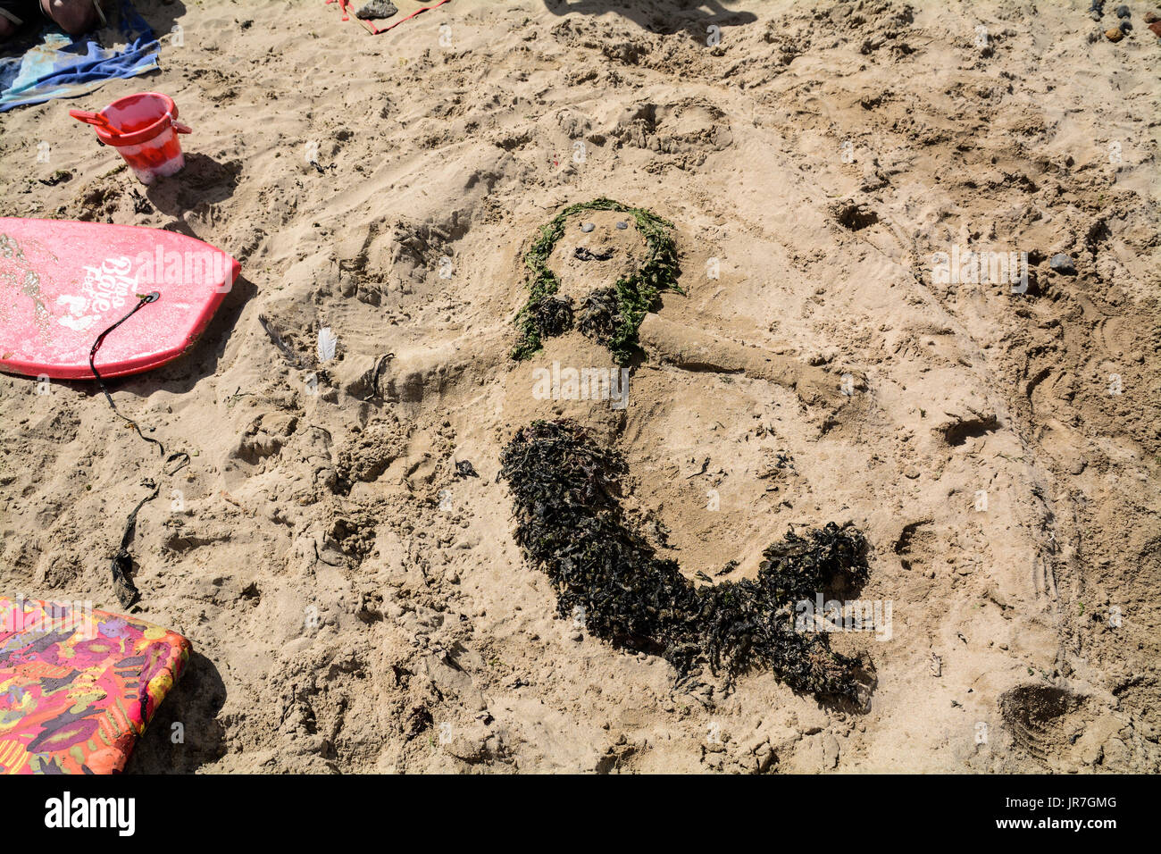 Mousehole, Cornwall, UK. 3rd August 2017. UK Weather. It was a sunny start for the annual Mousehole carnival which runs over the weekend. The afternoon saw a sand sculpture competition on the tiny harbour beach. At high tide locals and holiday makers enjoyed leaping off the harbour walls into the sea - which had a reported temperature of 21 degrees C Credit: cwallpix/Alamy Live News Stock Photo