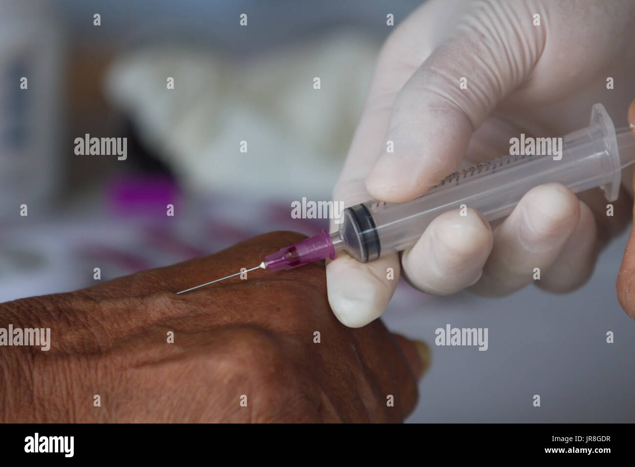 Close-up Of Doctor Injecting Patient With Syringe To Collect Blood ...