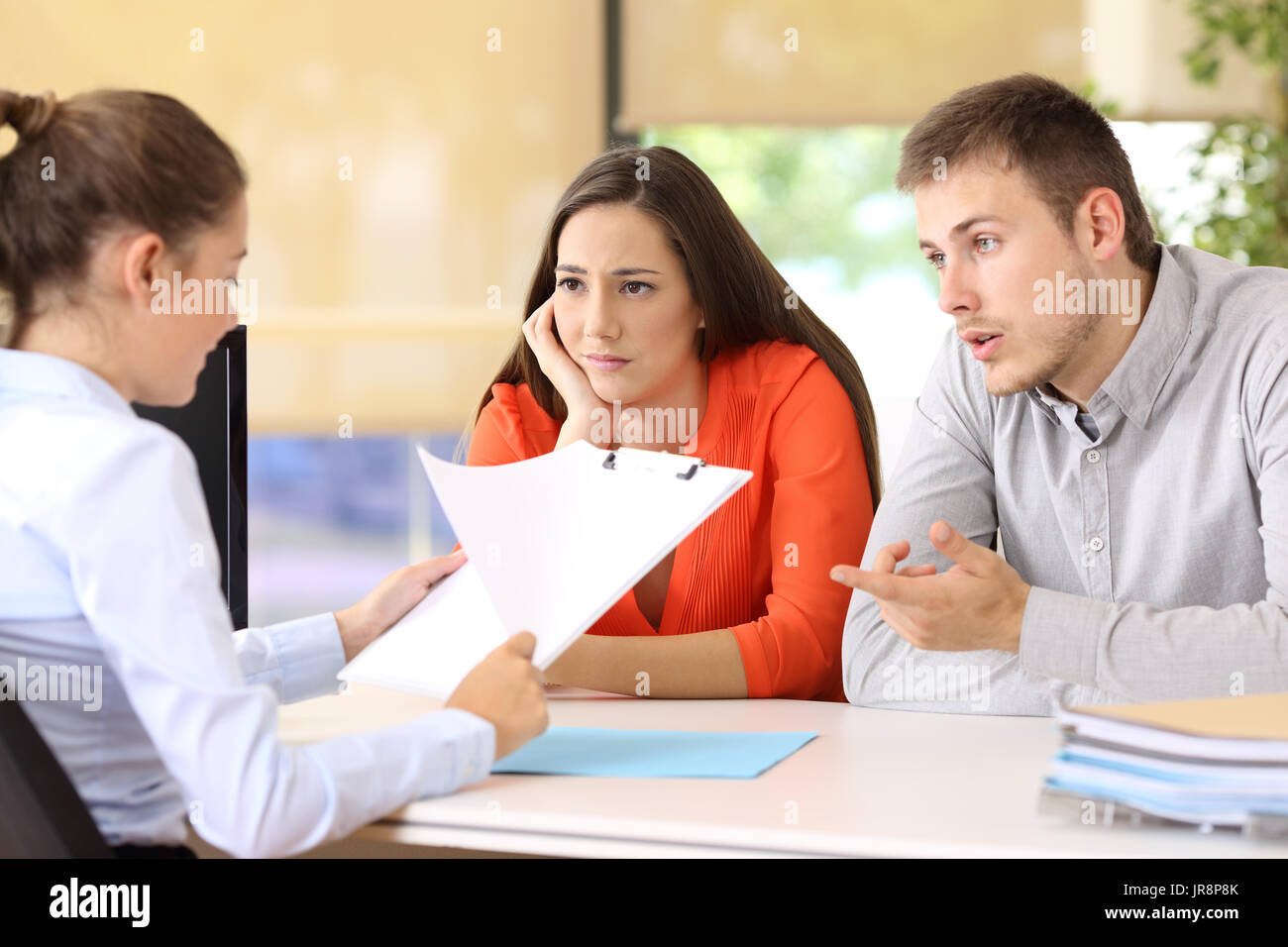 Sad couple with problems talking in a marriage counseling Stock Photo