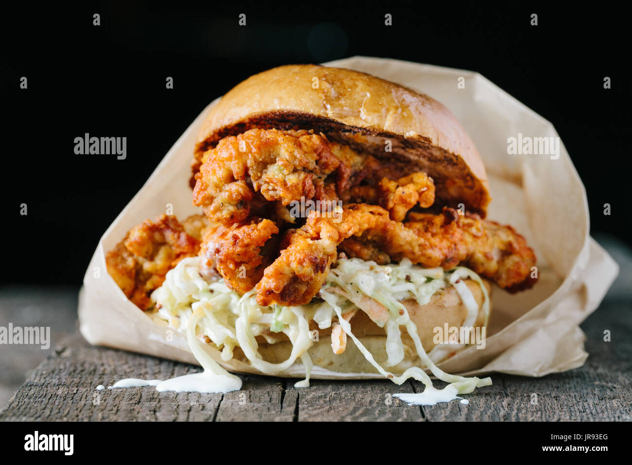 Fried crispy chicken sandwich with coleslaw on dark background horizontal Stock Photo