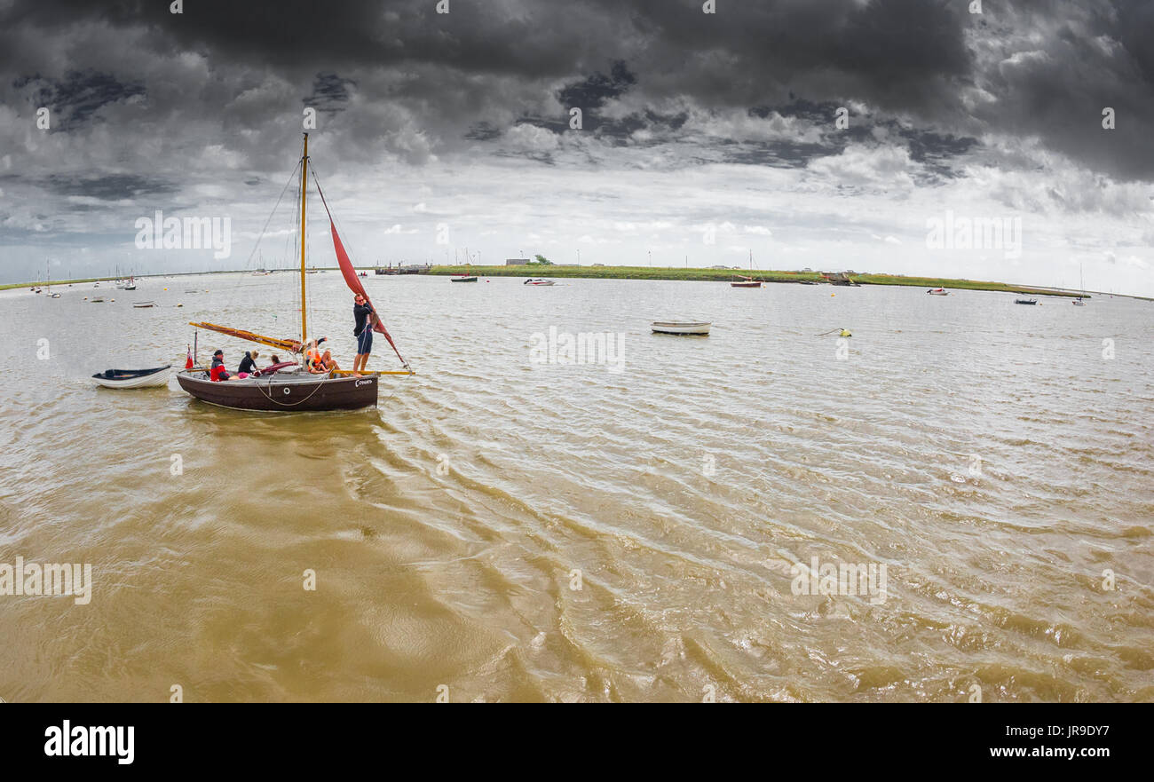 Family setting sail in a traditional wooden yacht out of Orford harbour. Stock Photo