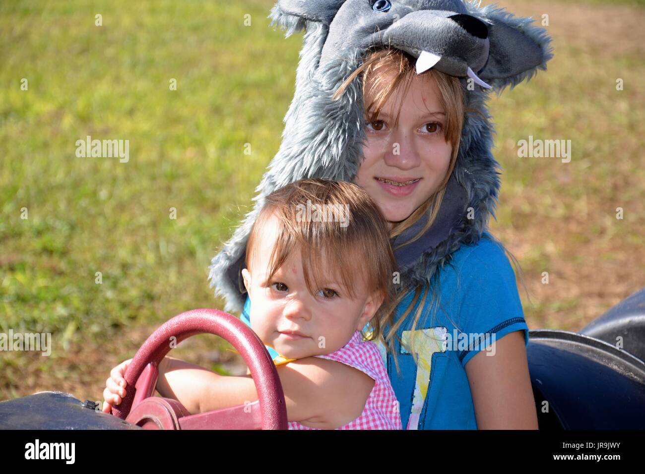 funYoung girl and female toddler (sisters) riding a barrel train at a fall festival. Stock Photo