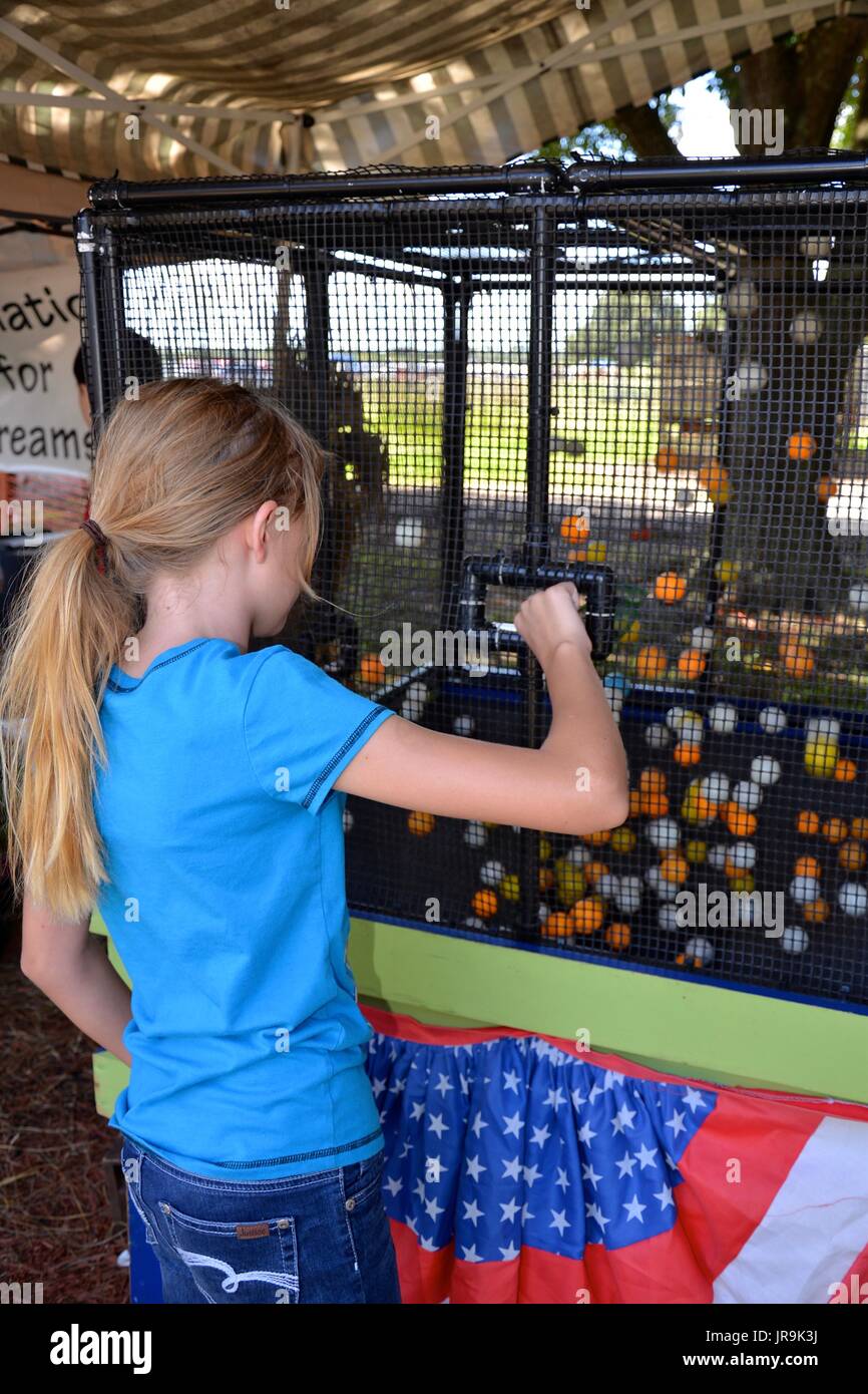 Young girl having fun playing games at a fall festival. Stock Photo