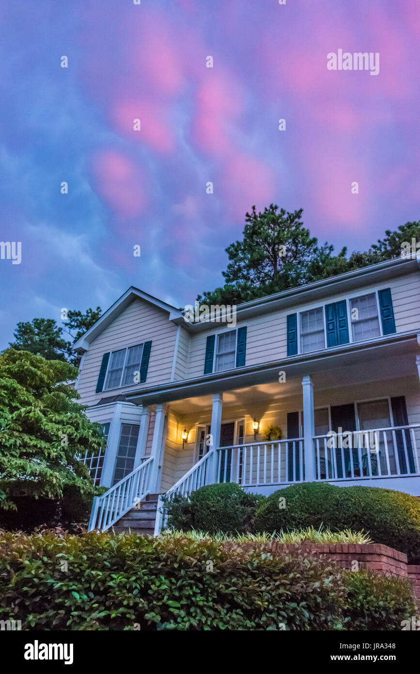 Colorful sunset clouds paint the sky as evening falls over a home in Metro Atlanta, Georgia. (USA) Stock Photo