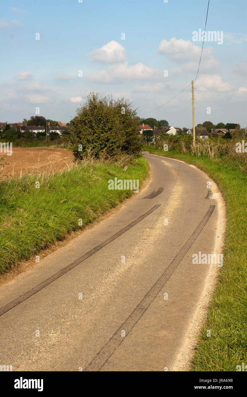 Car rubber tire skid marks left by young drivers going too fast in a country lane Stock Photo