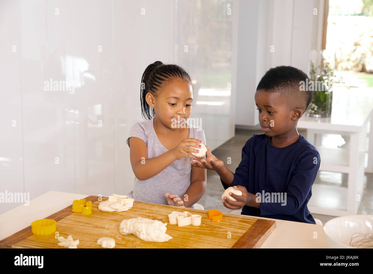 brother and sister making cookies Stock Photo