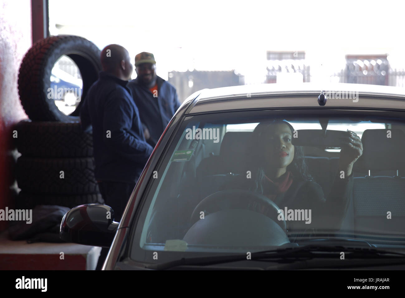 African woman adjusting rearview mirror Stock Photo