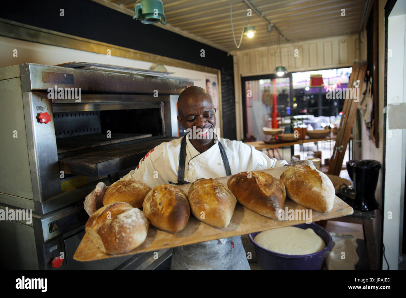 Baker holding tray of fresh bread Stock Photo