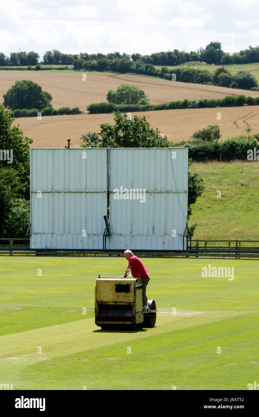 A man rolling the village cricket pitch, Rushton, Northamptonshire, England, UK Stock Photo Alamy