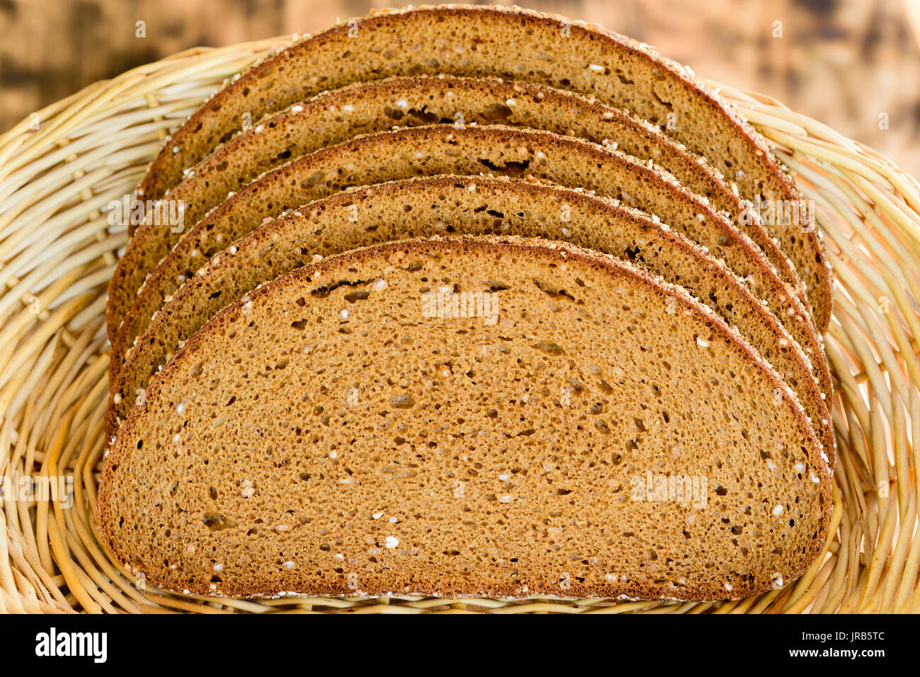 Sliced whole grain bread in a wicker basket. Stock Photo