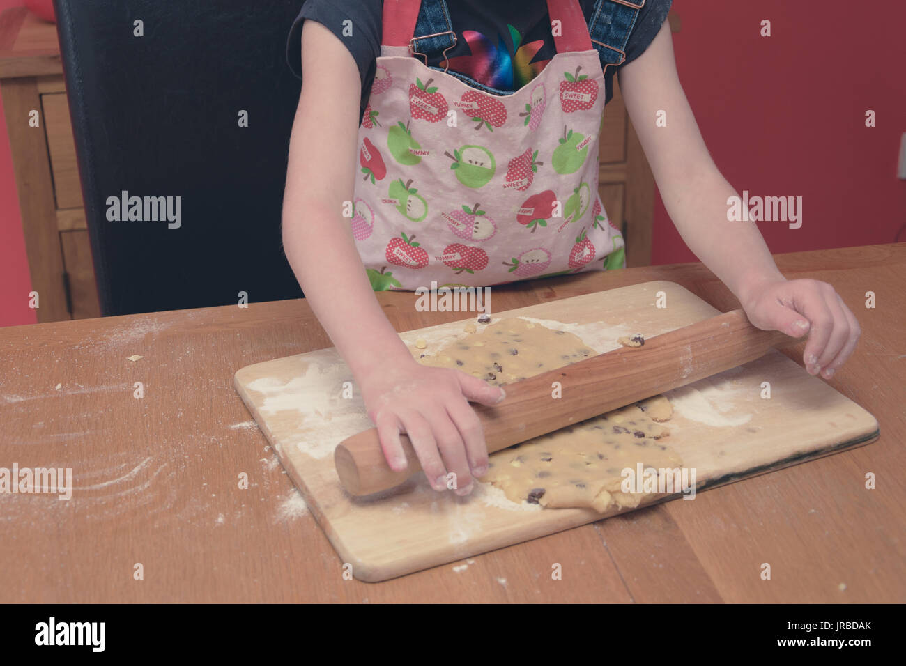 little girl baking cookies in a cute pink chefs hat and apron Stock Photo