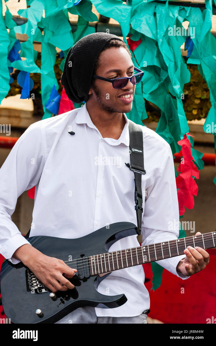 Young black man, afro-Caribbean, 20s, playing guitar. Member of the band Generation Uncovered performing outdoors at the Ramsgate Festival. Stock Photo