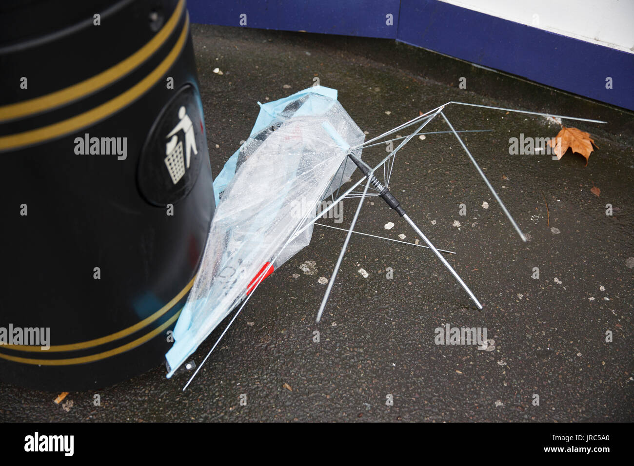 Broken umbrella next to a litter bin on London street. Stock Photo