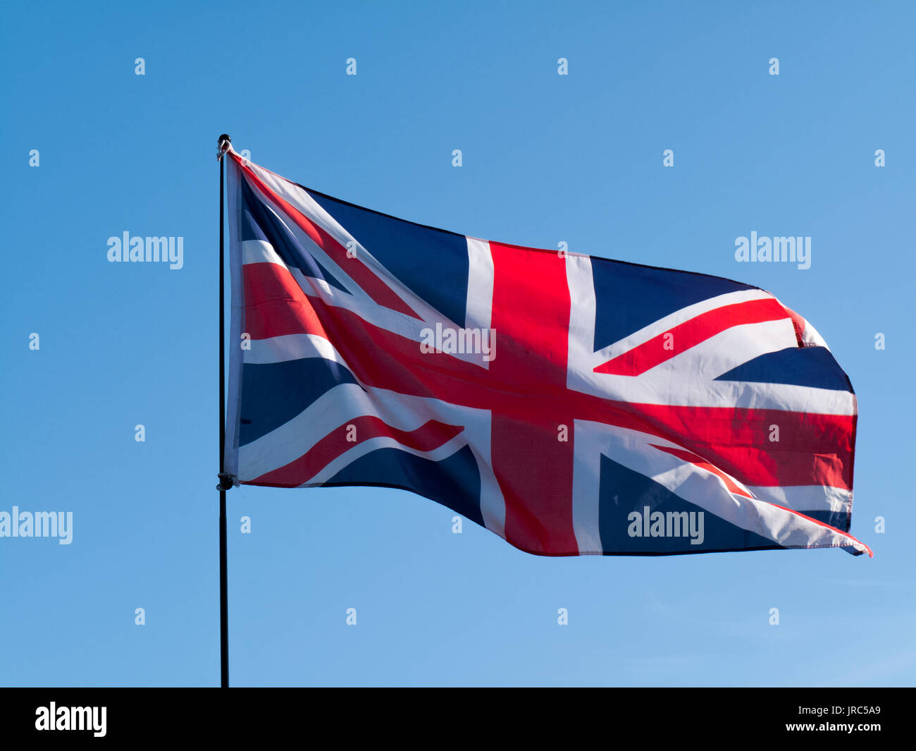 United Kingdom Union Jack Flag against a clear blue sky Stock Photo - Alamy