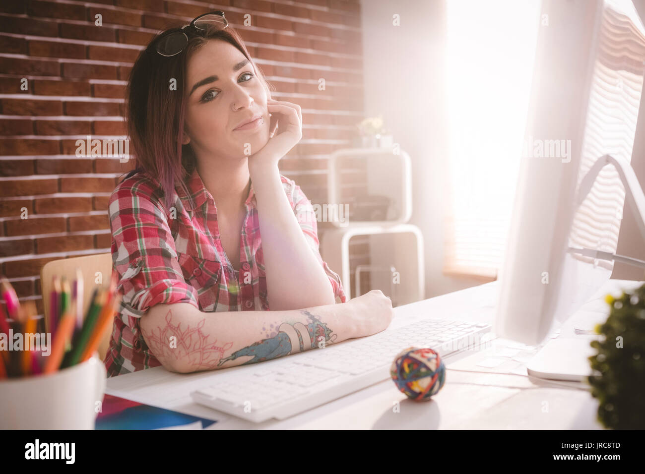 Portrait of smiling executive sitting with hand on face in office Stock ...